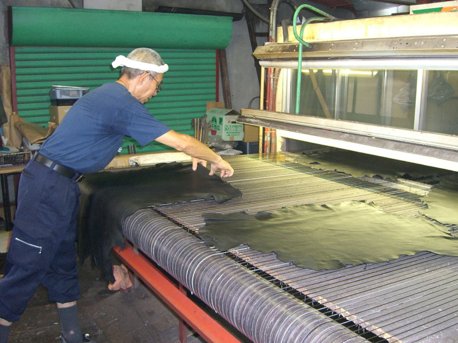 すでに色のついた革の上に、さらに染色をし、色を均一にする作業。